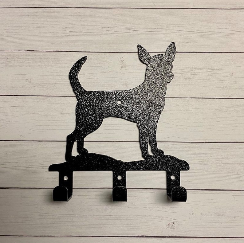 Puede incluir: Porta llaves de metal negro con forma de perro chihuahua con tres ganchos.