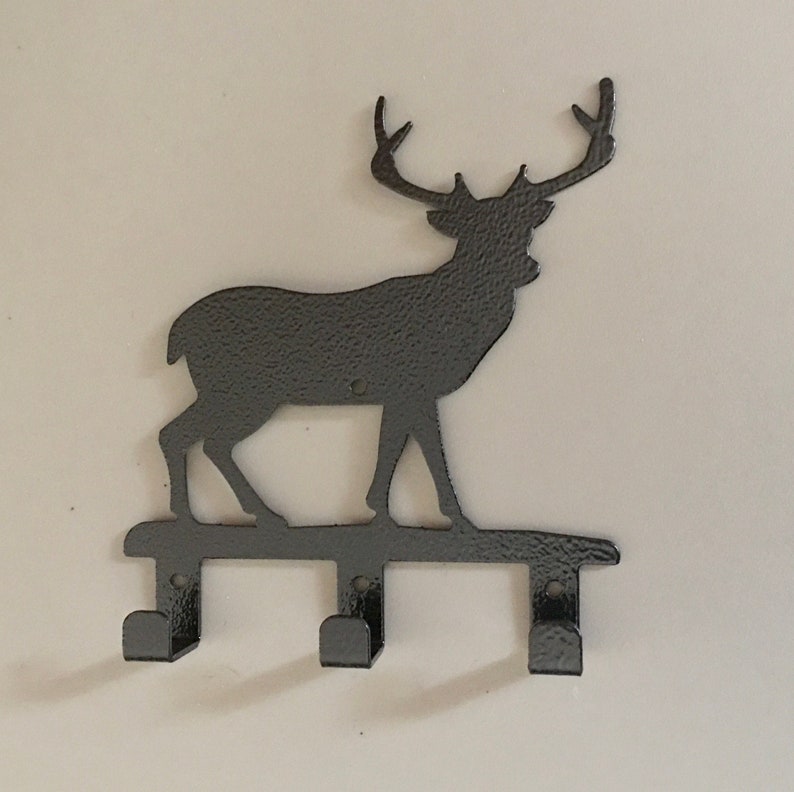 Op de afbeelding: Zwarte metalen sleutelhanger met hert silhouet en drie haken.