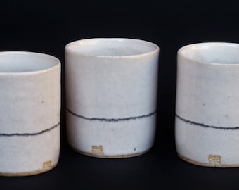 Everyday glass mug made of stoneware glossy white Mishima technique. Cylindrical or ergonomic shape, slightly flattaned on the side