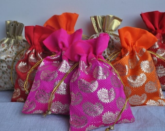 Puede incluir: Una colección de coloridas bolsas con cordón en tonos rojos, naranjas, rosas y dorados. Las bolsas presentan un estampado de cachemira y cordones dorados, perfectas para pequeños regalos o almacenamiento.