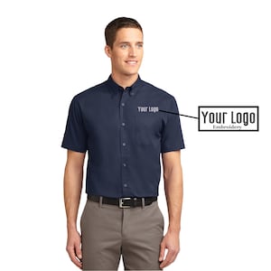 May include: A navy blue short-sleeve button-down shirt with a pocket on the left chest. The shirt has a white embroidered logo that says "Your Logo" on the pocket.