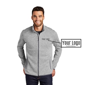May include: A gray full-zip fleece jacket with a high collar and two front pockets. The jacket has a dark gray zipper and trim. The text "Your Logo Embroidery" is displayed on the right chest area.