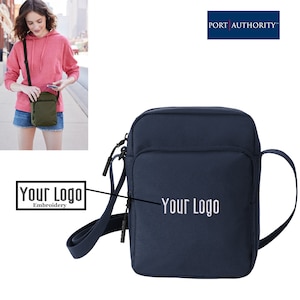 May include: A navy blue crossbody bag with a zippered pocket and an adjustable strap. The bag has a white embroidered logo that says "Your Logo".