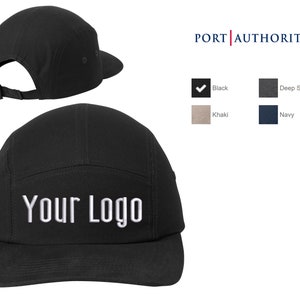 May include: A black 5-panel cap with a flat brim and a white embroidered "Your Logo" on the front. The cap is available in black, deep smoke, khaki, and navy.