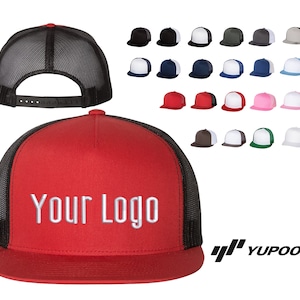 May include: A red and black trucker hat with a white mesh back. The hat has a black strap and a white embroidered logo that says "YOUR LOGO".