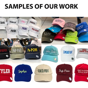 May include: A collection of baseball caps and visors in various colors including white, black, blue, red, green, and tan. The headwear features embroidered text such as Gaga, Mom, Papadoo, Team Sach, Samantha, Coach Phive, and Make Crawfish $1.97/LB Again.