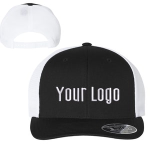 May include: Black and white trucker hat with a white mesh back. The front of the hat is black with white embroidered text that says "YOUR LOGO".