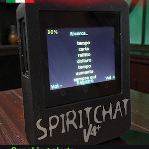 May include: A black SpiritChat V4+ device with a screen displaying Italian text, including "Ricerca" and "tempo." The device has volume controls and features "Speaking alerts" and "Magnetometer Trigger."