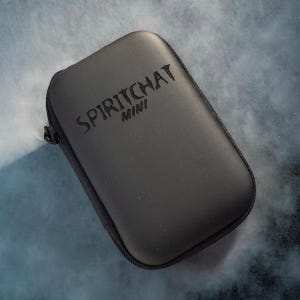 Könnte beinhalten: Ein schwarzes, rechteckiges Etui mit Reißverschluss. Der Text "SPIRITCHAT MINI" ist auf der Oberseite geprägt. Das Etui befindet sich auf einem blau-grauen Hintergrund.