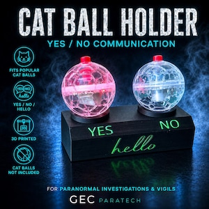 May include: A black rectangular base with the words YES, NO, and hello printed in green, supporting two clear, spherical cat ball holders. The left holder glows pink, while the right holder is clear. Text includes CAT BALL HOLDER and YES / NO COMMUNICATION.