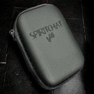 May include: A black carrying case with a zipper closure. The case has the text "SPRITCHAT V4" printed on the front.