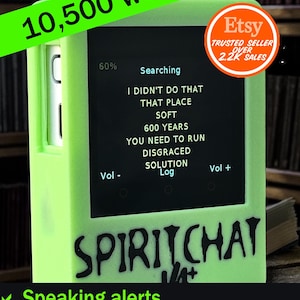 May include: A bright green electronic device with a black screen showing text. The device has volume controls and the word "SPIRITCHAT" is printed on the front. The image also includes the text "10,500 words!" and "Speaking alerts" and "Magnetometer Trigger".