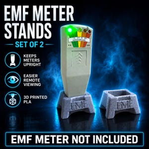 May include: A set of two grey 3D printed PLA stands for an EMF meter. One stand holds a grey K-II EMF meter with a lit green indicator light and a scale reading in milliGAUSS. The stands feature the letters EMF embossed on the front base.