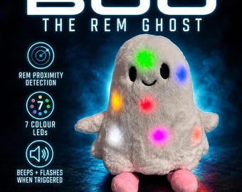 May include: A white plush ghost toy named BOO THE REM GHOST with black eyes and pink feet. The ghost features seven colored LED lights that glow. Text on the image includes REM PROXIMITY DETECTION, 7 COLOUR LEDS, BEEPS + FLASHES WHEN TRIGGERED.