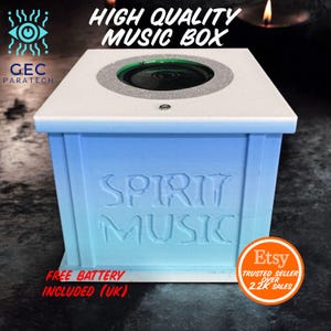 Puede incluir: Una caja de música blanca y azul con el texto "SPIRIT MUSIC" en la parte delantera. La parte superior tiene un altavoz y las palabras "HIGH QUALITY MUSIC BOX". El logotipo de Etsy es visible.