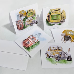 May include: A collection of watercolor greeting cards featuring Georgia Tech imagery. The cards depict a football helmet, a vintage car, a stadium, and a building with the letters "TECH". The cards are white with watercolor illustrations.