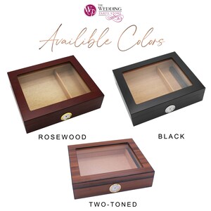 May include: Three rectangular cigar humidors with glass tops and front-mounted analog hygrometers. The collection includes a dark rosewood finish, a solid black finish, and a two-toned wood grain finish, each featuring an internal wooden divider.