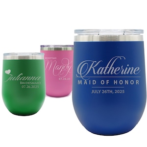 May include: Three stemless wine tumblers in green, pink, and blue. Each tumbler is personalized with a name and date in silver script. The blue tumbler reads "Katherine, Maid of Honor, July 26th, 2025."