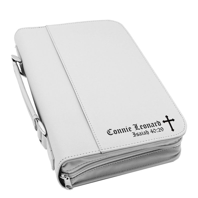 May include: A white Bible cover with a handle and zipper closure. The cover has the name "Connie Leonard" and the text "Isaiah 40:29" with a cross symbol printed on the front.