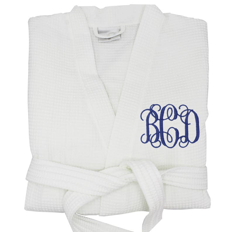 May include: White waffle weave robe with a navy blue monogrammed "B.C.D." on the right side.