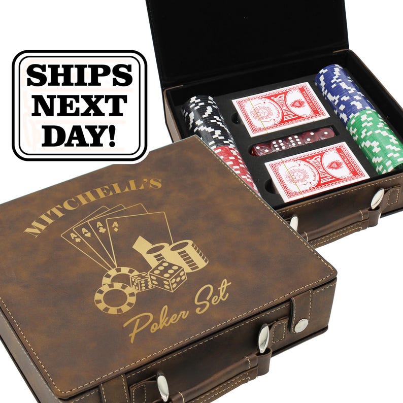 May include: A brown faux leather poker set case with a handle and metal latches. The lid features a gold engraved design of playing cards, poker chips, dice, and the text Mitchell's Poker Set. Inside are stacks of chips, two decks of cards, and dice.