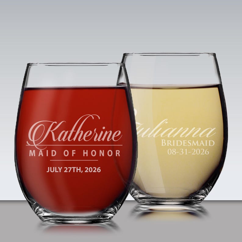 May include: Two stemless wine glasses, one filled with red liquid and the other with a yellow liquid. The red wine glass has the name "Katherine", the words "Maid of Honor", and the date "July 27th, 2026". The other glass has the name "Julianna", the word "Bridesmaid", and the date "08-31-2026".