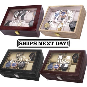 May include: Four rectangular watch display cases with glass lids and metal latches. The top left is dark wood with Henry, top right is light wood with a G, bottom left is black leather with Williams, and bottom right is brown leather with Miller.