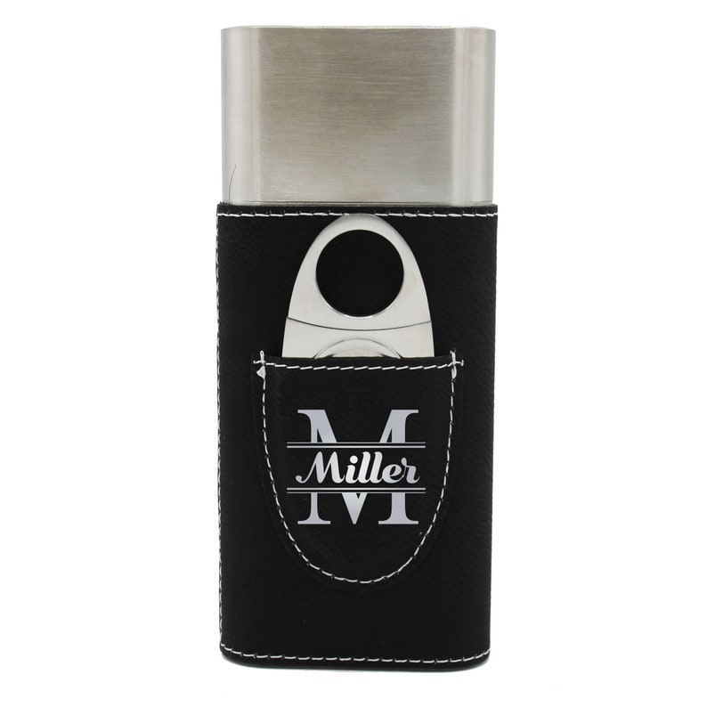 May include: A rectangular stainless steel cigar case with a black leather sleeve featuring white contrast stitching. A silver cigar cutter is tucked into a front pocket that displays the letter M and the name Miller in white lettering.