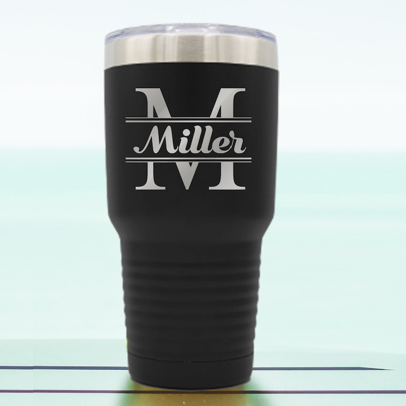 May include: Black stainless steel tumbler with a personalized engraved design. The design features a large letter "M" with the name "Miller" centered below it.