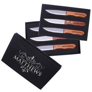 May include: A set of four steak knives with wooden handles in a black box. The knives are engraved with the name "MATTHEWS".