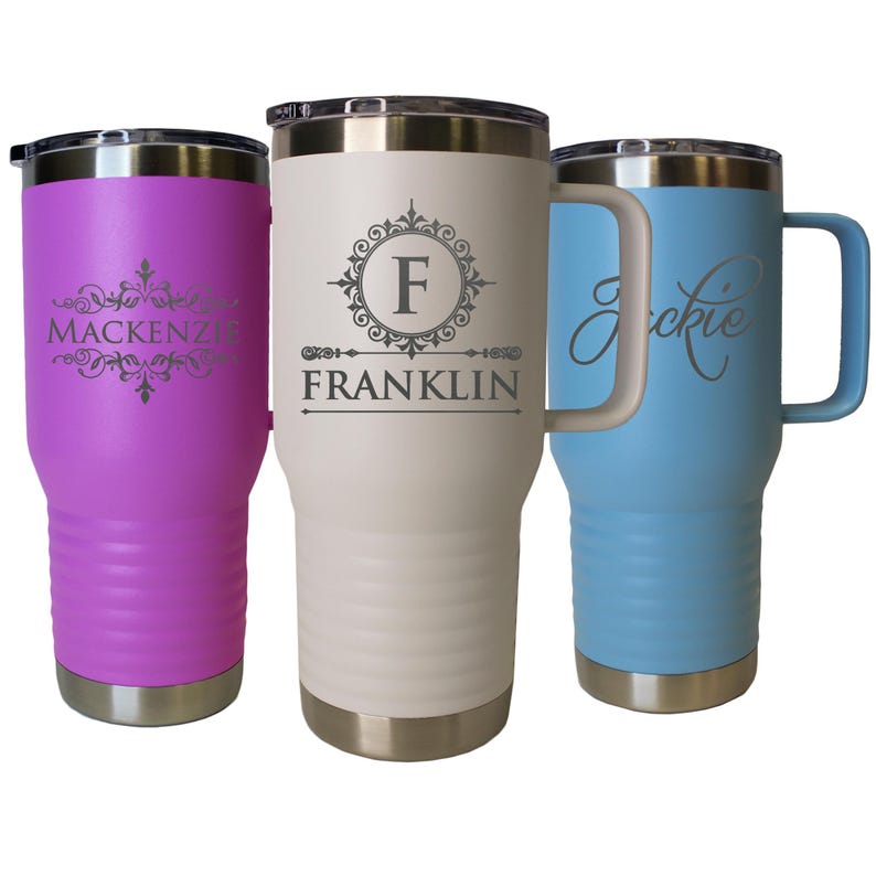 Pode incluir: Tr&ecirc;s canecas isoladas em roxo, creme e azul claro. A caneca roxa tem o nome "Mackenzie" em uma fonte decorativa. A caneca creme tem a letra "F" dentro de um desenho circular com o nome "Franklin" abaixo. A caneca azul claro tem o nome "Jackie".