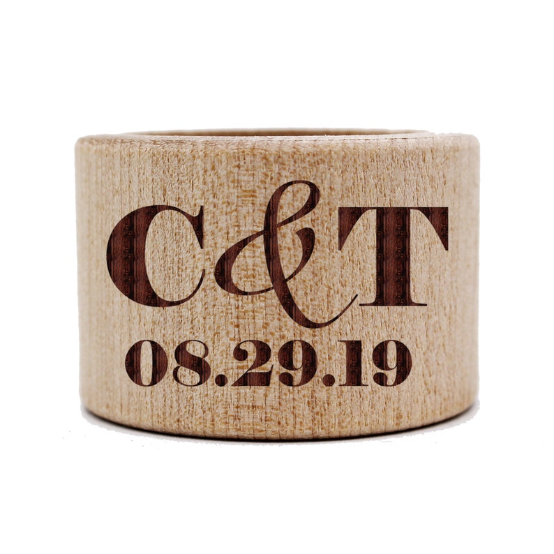 May include: A wooden ring holder engraved with the initials "C & T" and the date "08.29.19".