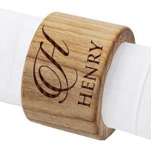 May include: Wooden napkin ring engraved with the name "HENRY" and a cursive letter "H".