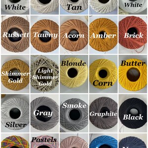 May include: A collection of 20 spools of thread in various colors, including white, tan, russet, tawny, acorn, amber, brick, shimmer gold, light shimmer gold, blonde, corn, butter, silver, gray, smoke, graphite, black, rainbow, pastels, vintage, azure, and navy.
