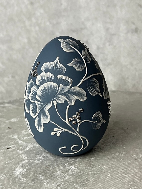 Porcelain Egg with hand painted dimensional white roses. The blue color gives it a "Wedgewood Look"  Perfect addition to any Easter Basket