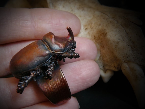 An actual rhinoceros beetle electroformed in copper and turned into a ring — 299 favorites proves people are absolutely here for wearable insect armor.