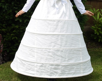 May include: A white, multi-layered petticoat with a gathered skirt and a white ribbon tied at the waist.