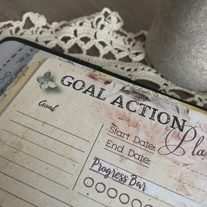 May include: A vintage-style planner page with the words "GOAL ACTION Plan" in black lettering. The page has a floral design and a butterfly illustration. It includes sections for start and end dates, and a progress bar.