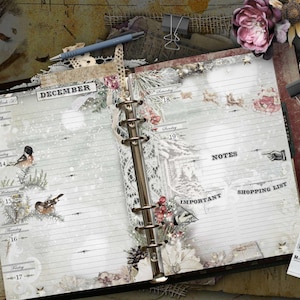 An open ring-bound planner with a winter theme featuring the text DECEMBER, Week 50, and days of the week from Monday 13 to Sunday 19. The pages include sections for NOTES, IMPORTANT, and SHOPPING LIST, decorated with birds, pine branches, and snow.