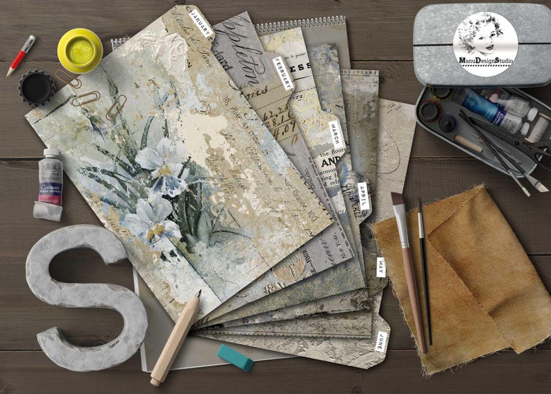May include: An artistic still life featuring a stack of decorative papers labeled with months, a metal tin with art supplies, paint tubes, brushes, and a large letter "S". The papers have floral and script designs.