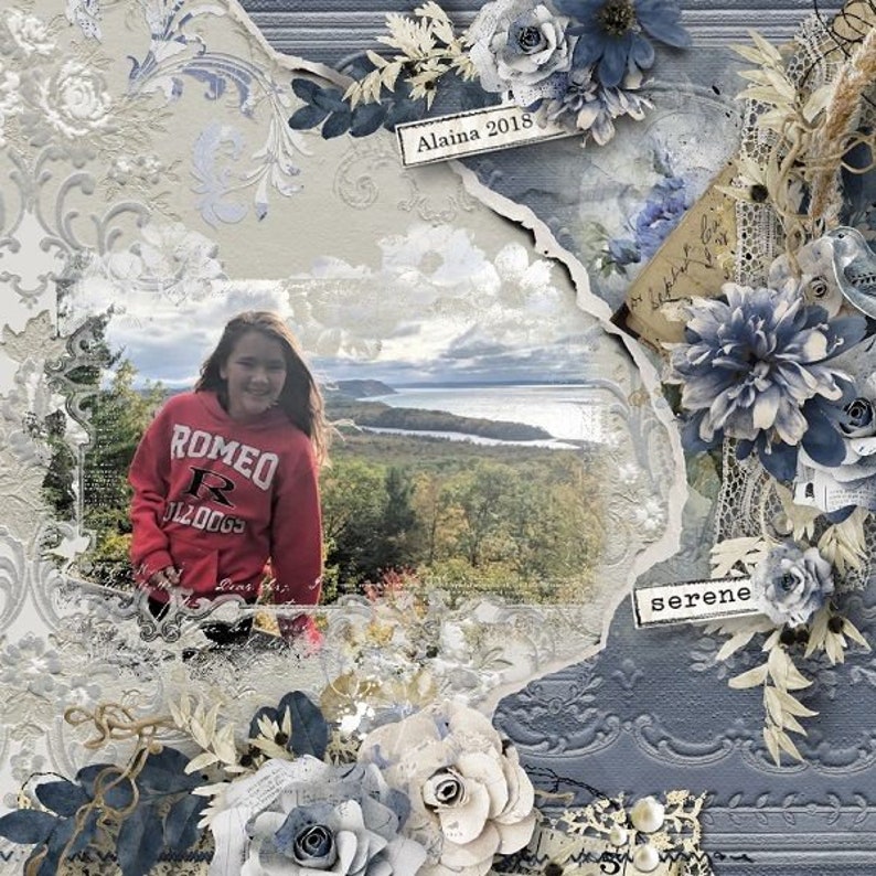 May include: A scrapbook page with a torn paper background, a photo of a girl in a red sweatshirt, and blue and white flowers. The page is decorated with lace, a vintage postcard, and the text "Alaina 2018" and "serene".