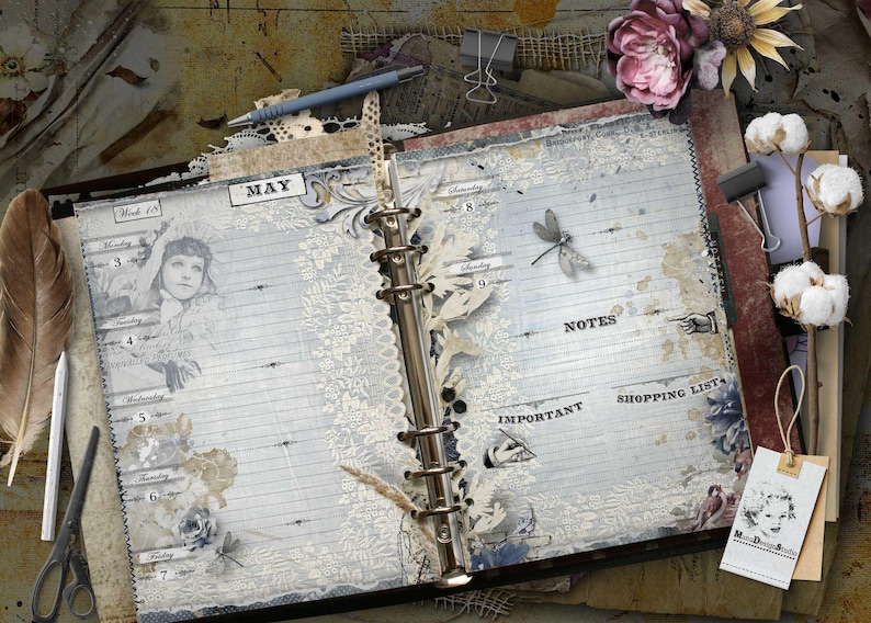 An open ring-bound planner with vintage-style graphics, including a portrait of a person, a dragonfly, and lace patterns. The pages feature the text MAY, NOTES, IMPORTANT, and SHOPPING LIST, with sections for days of the week.