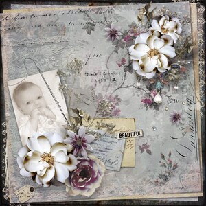 May include: A vintage-style scrapbook page with a baby photo, faux flowers, and aged paper elements. The color palette includes soft blues, creams, and purples. The word "BEAUTIFUL" is visible on a small label. The overall theme is a nostalgic, handcrafted design.