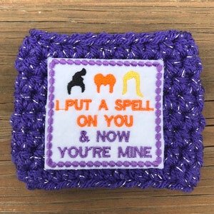 May include: Purple crocheted coaster with a white square patch featuring three witch silhouettes and the text "I put a spell on you & now you're mine".