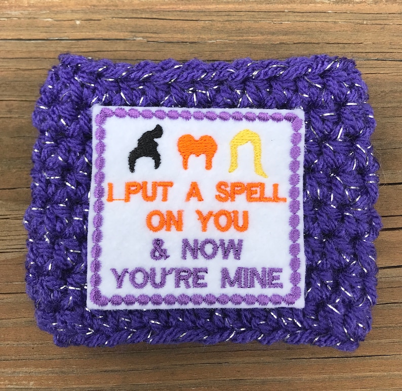 May include: Purple crocheted coaster with a white square patch featuring three witch silhouettes and the text "I put a spell on you & now you're mine".