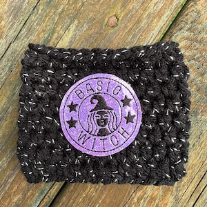 May include: Black crocheted coffee cup cozy with a purple glitter patch that says "BASIC WITCH" with a witch silhouette inside the circle.