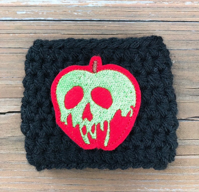 Pu&ograve; includere: Sottobicchiere in crochet nero con una mela ricamata in rosso e verde con un designo a forma di teschio.