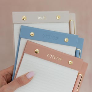 Może przedstawiać: Biały ceramiczny kubek z czarnym uchwytem i napisem "But First, Coffee" czarną, odręczną czcionką. Kubek stoi na białej powierzchni.