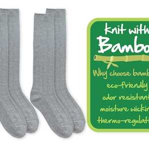 May include: Three pairs of gray knee-high socks made with bamboo. The socks are ribbed and have a soft, comfortable feel. The image also includes a green tag that reads "knit with Bamboo" and lists the benefits of bamboo: eco-friendly, odor resistant, moisture wicking, and thermo-regulating.