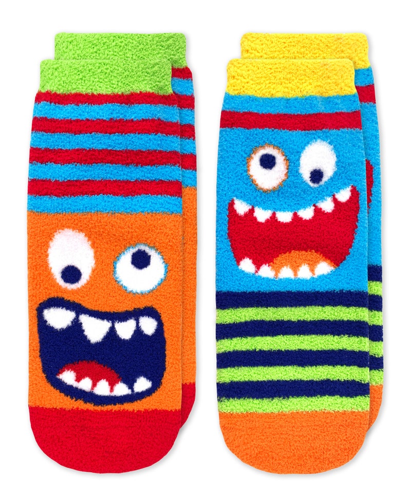 May include: Two pairs of fuzzy socks with monster faces. One pair has a blue monster face with a big smile and the other pair has an orange monster face with a big smile.